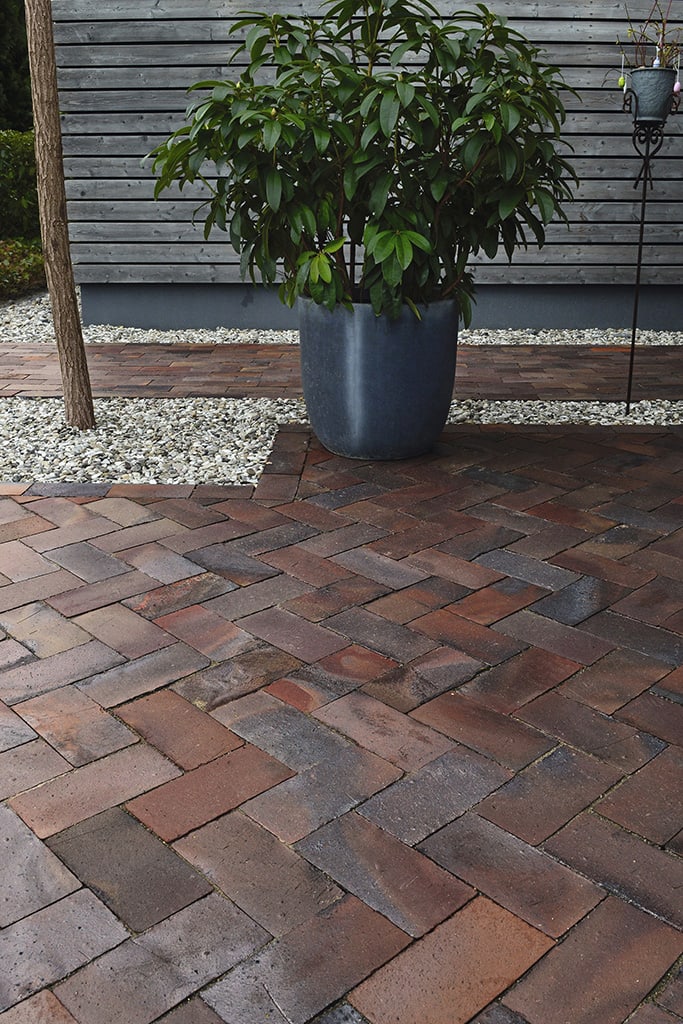 Backyard of a home with a large patio made of pavers and flagstone.