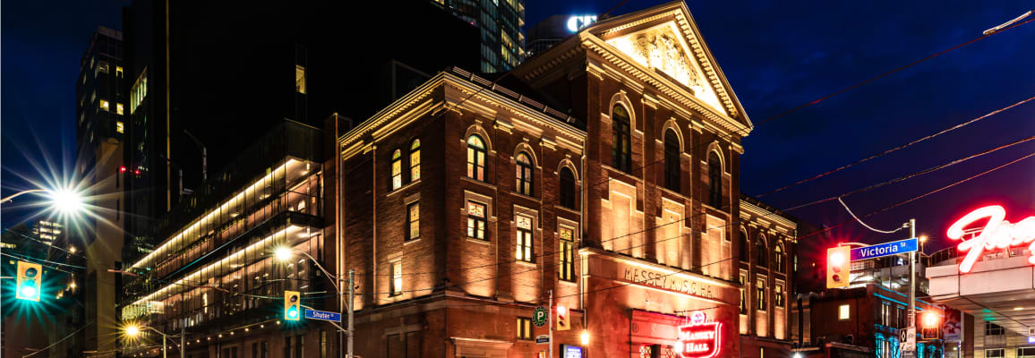 Massey Hall in Toronto with red brick lit up in the evening.