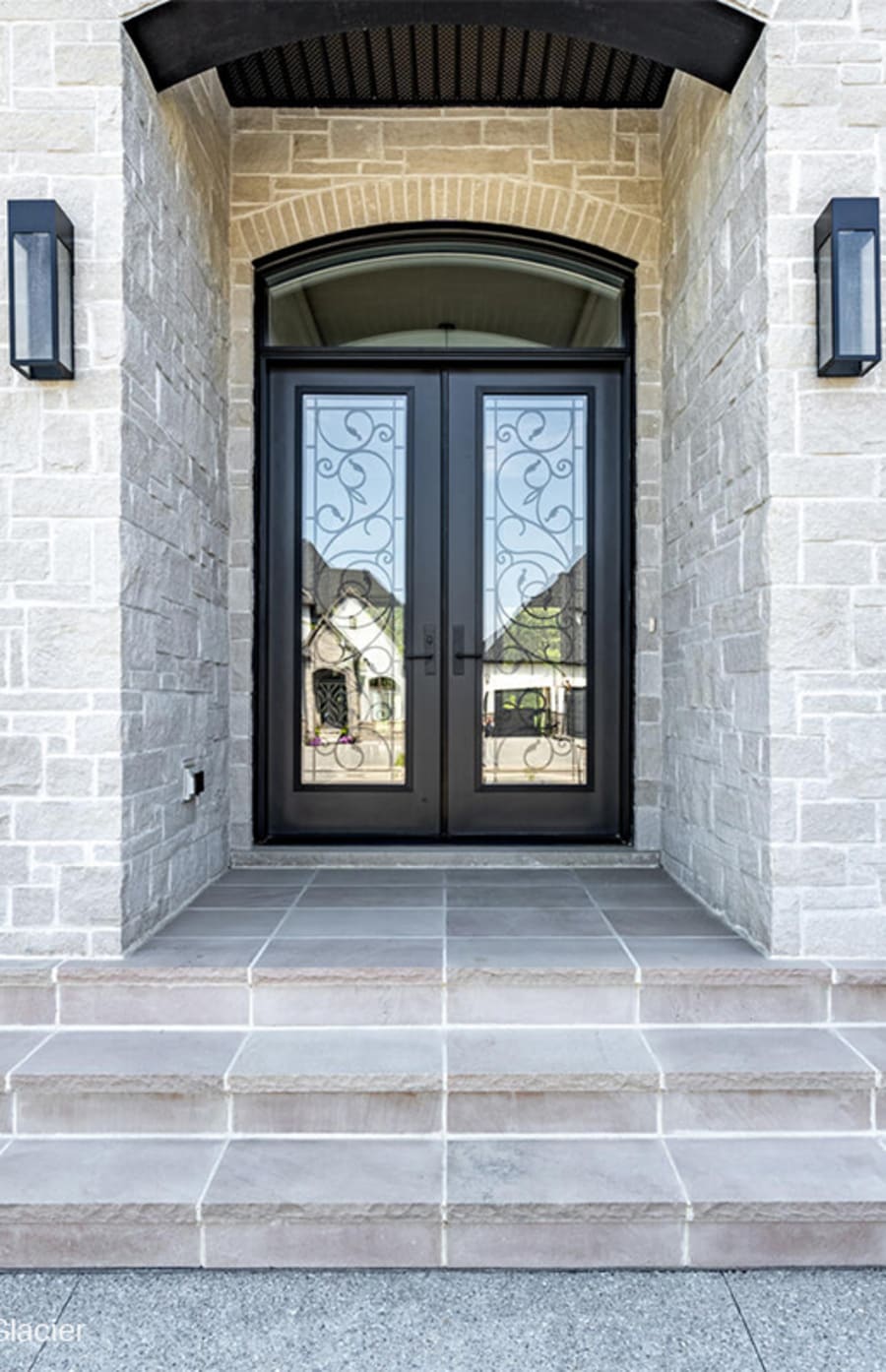 Light beige brick next to glass staircase.