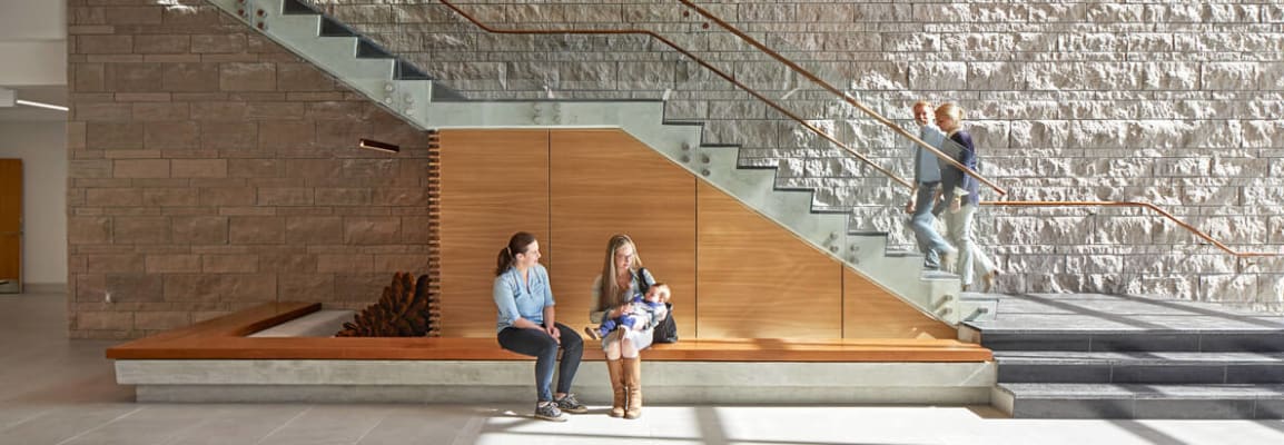 Light beige brick next to glass staircase.