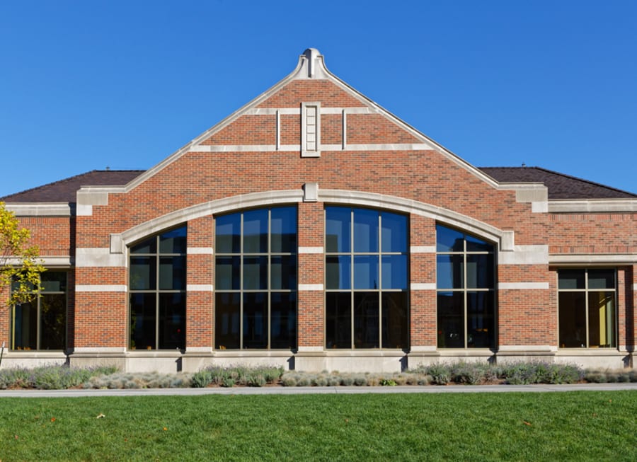 Exterior or red brick building with large windows.