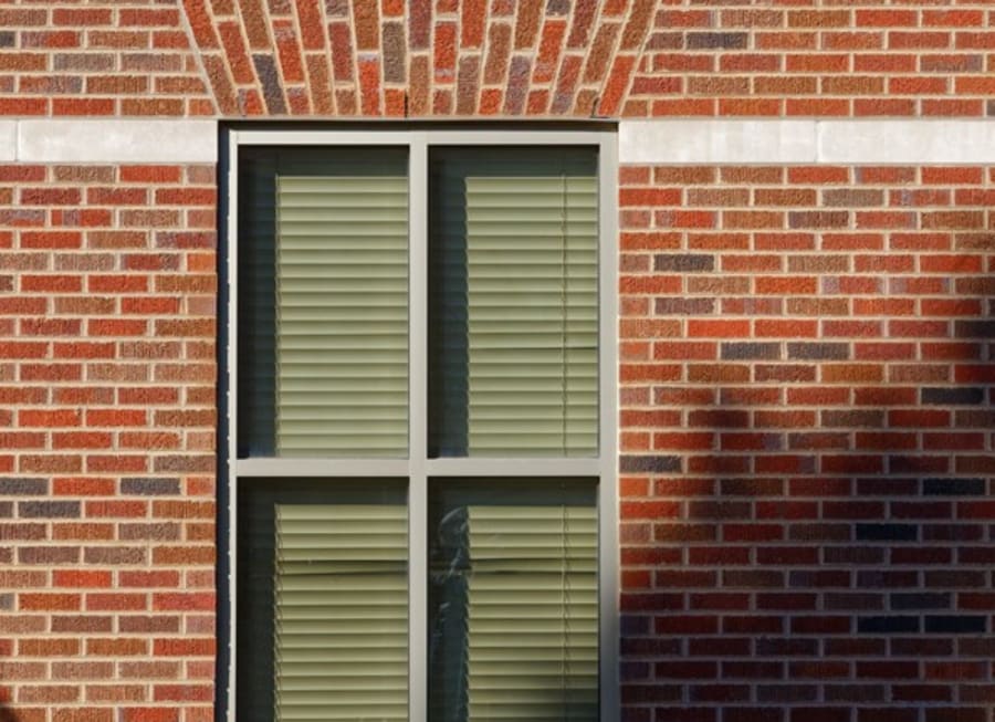 Exterior of a red brick building with a large window.