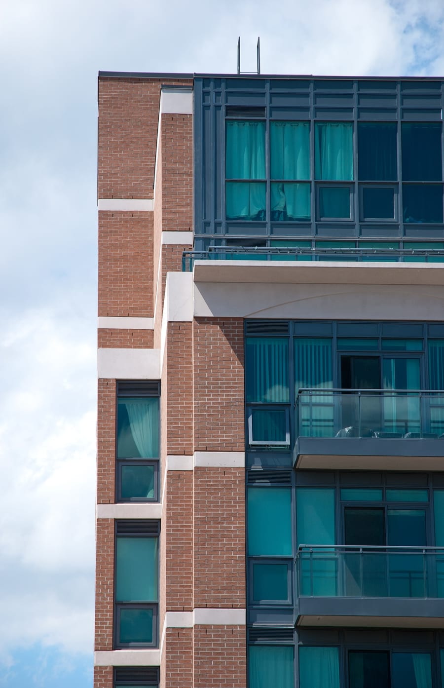 Multi-floor red brick building with large windows and balconies.