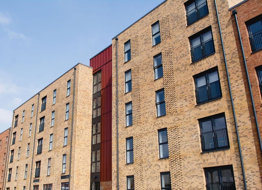 Exterior of apartment style building with dark beige brick.