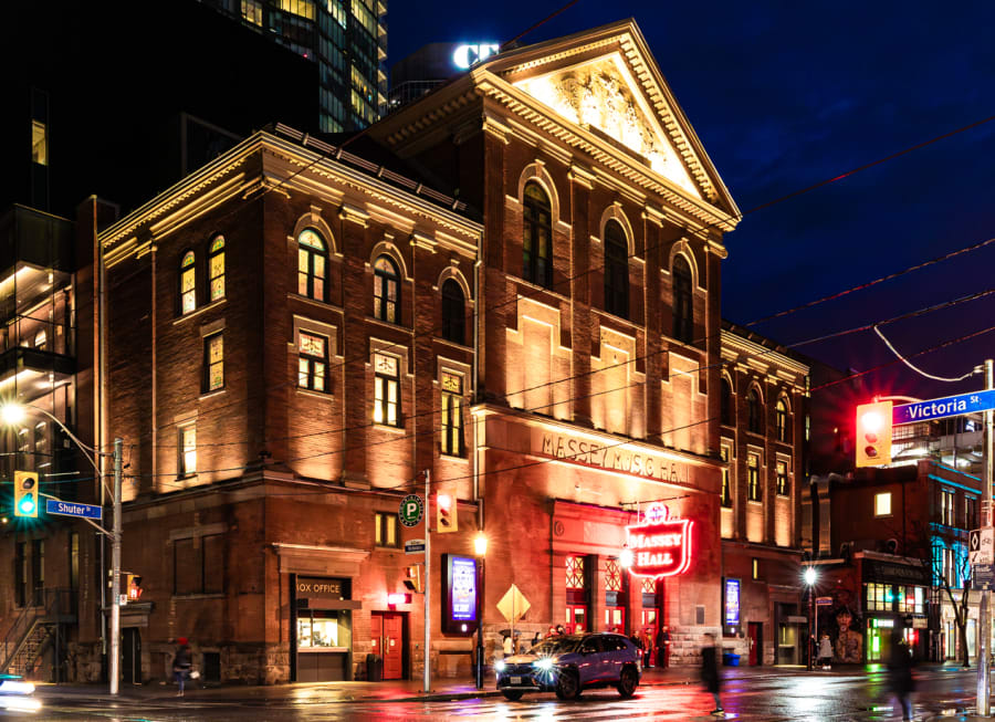 Exterior of Massey Hall in Toronto lite up in the evening.