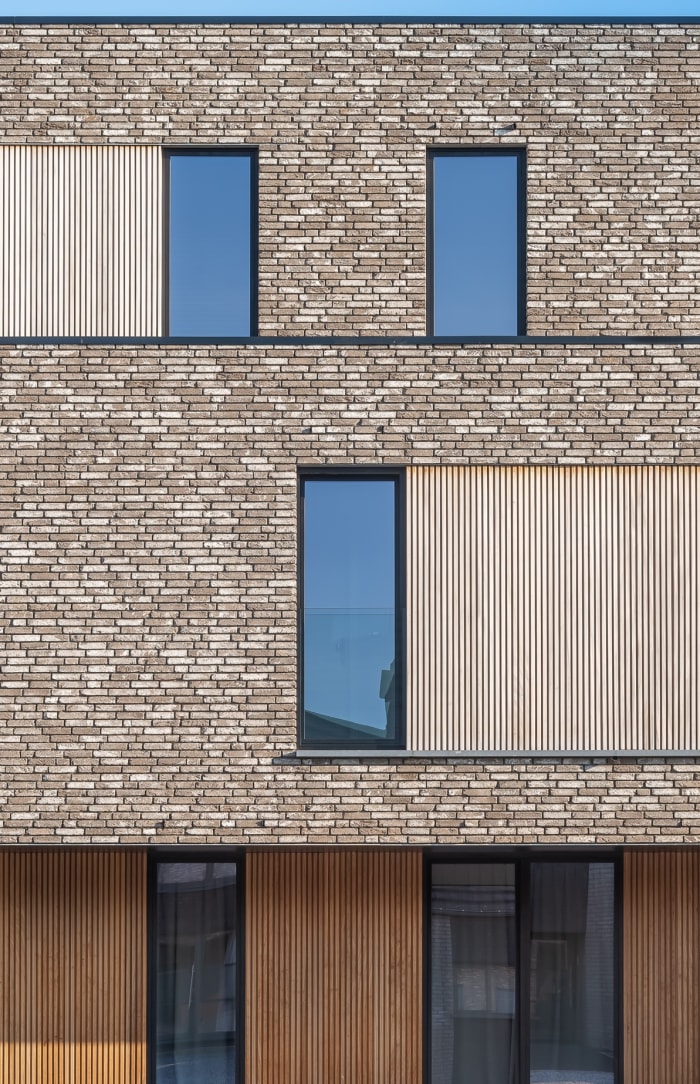 Exterior of large building with beige patterned bricks. 