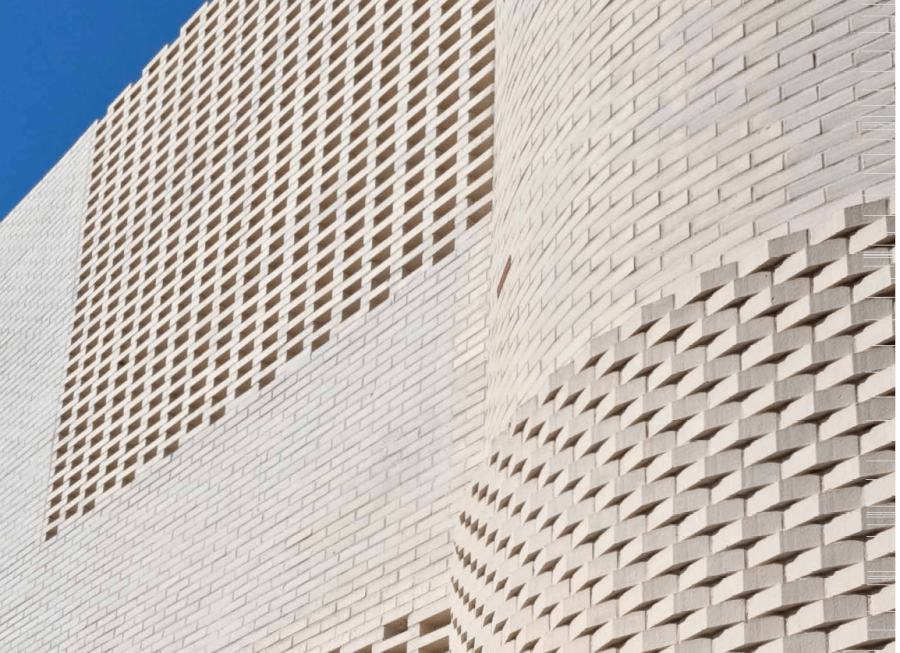 Light beige brick building with patterns.