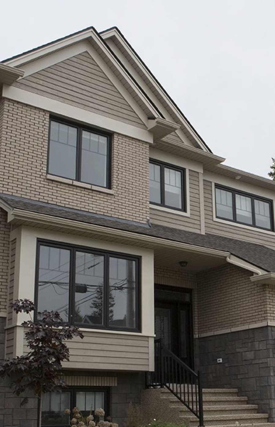 Two story residential house with beige brick.