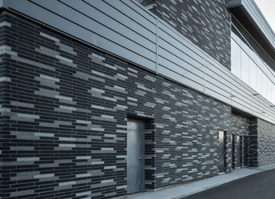 Exterior of a building with black and grey patterned bricks.