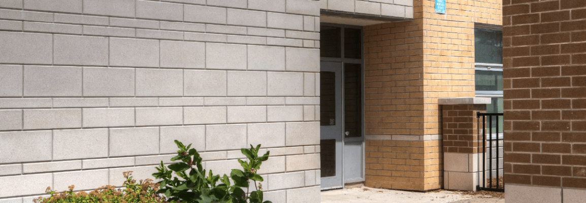 Exterior of a building with light beige, dark beige and red bricks.