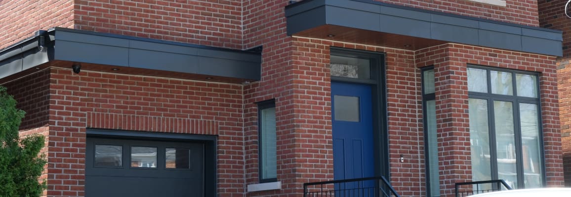 Exterior of a residential house with red brick and a blue door.