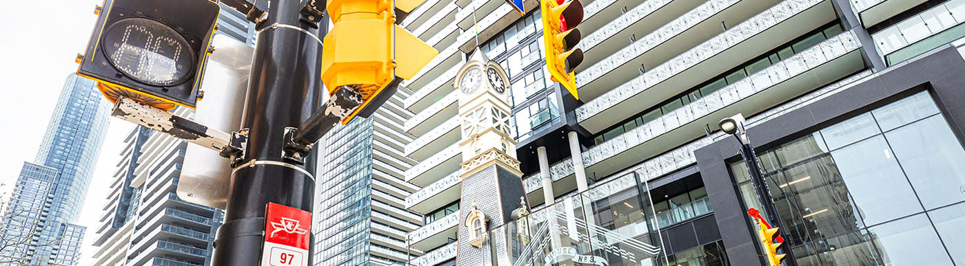 Ibstock clock tower in front of modern high-rise buildings.