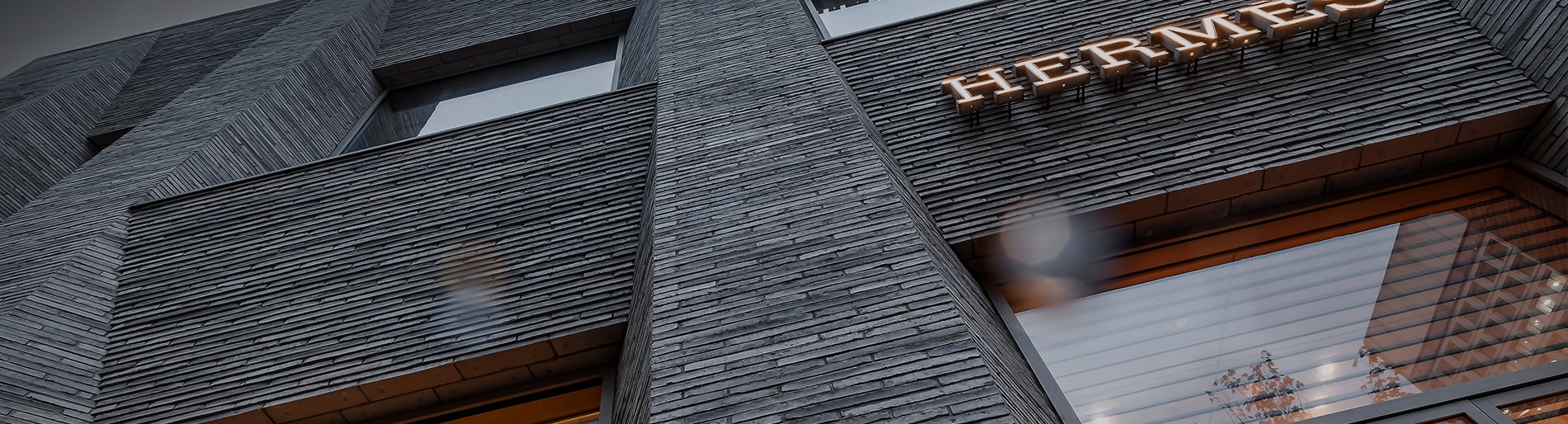 Close up exterior of an Hermes store with thin dark grey brick.