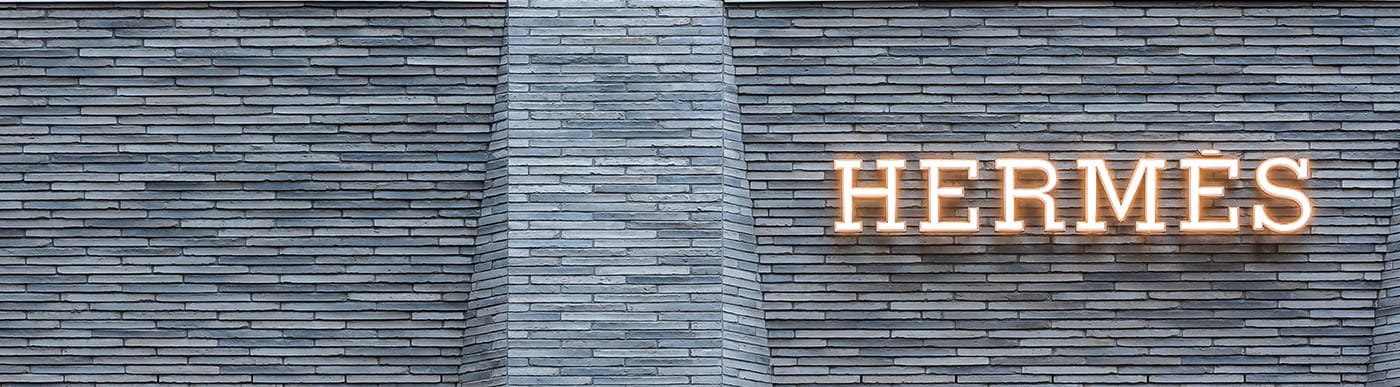 Close up of Hermes building sign with dark grey brick.