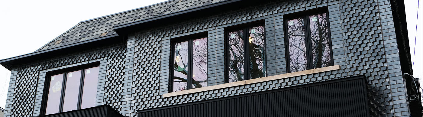 Exterior of a home with dark grey glazed brick.