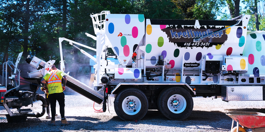 White concrete truck with multi-coloured polka dots.