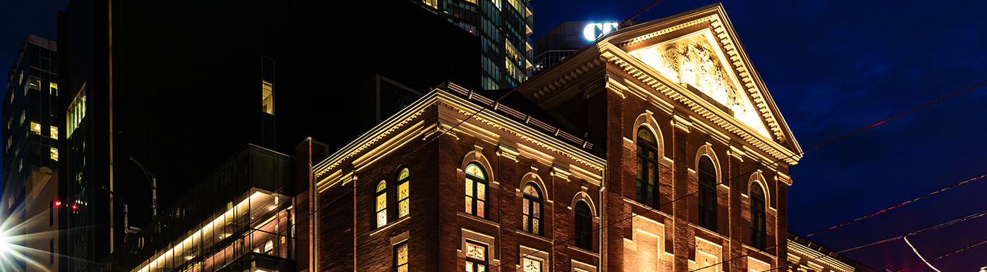 Massey Hall in Toronto in the evening with lights illuminating the red brick.