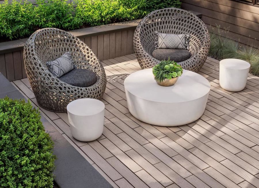 Exterior patio with beige patio stones and modern furniture.