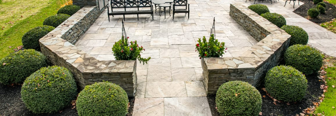 Patio with walls made of pavers and flagstone.