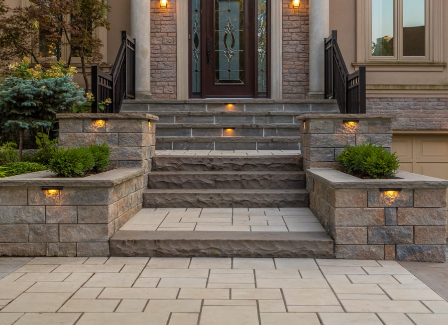 Front steps to a house with grey pavers and flagstone.