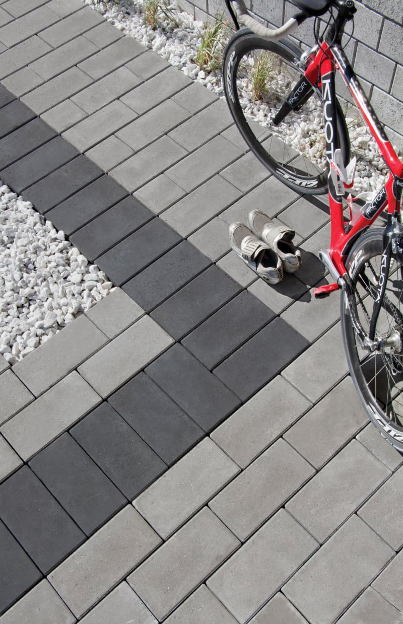 Grey walkway with red bike leaned against a wall.