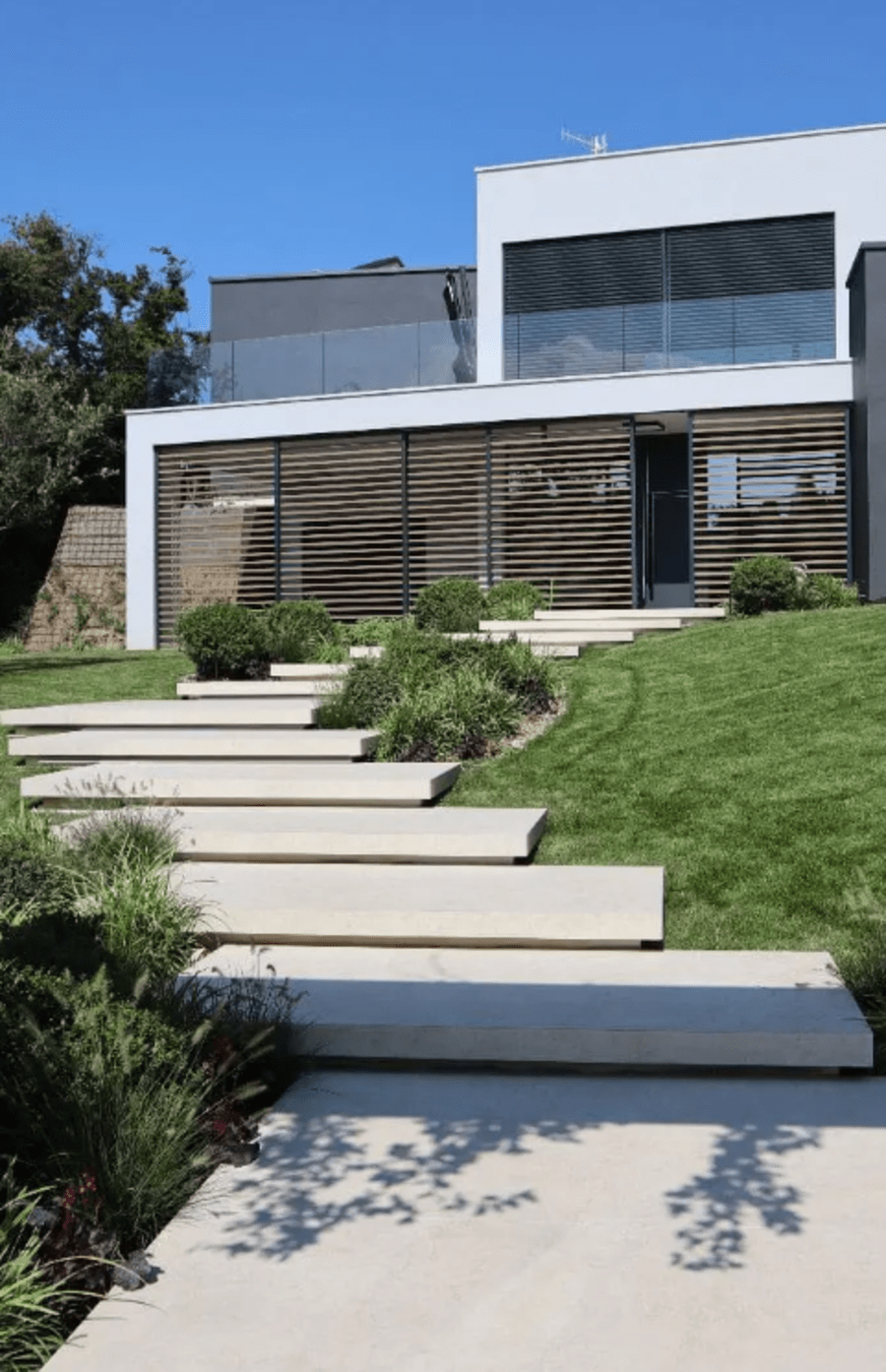 Exterior grey stone stairs leading to the front of a house.