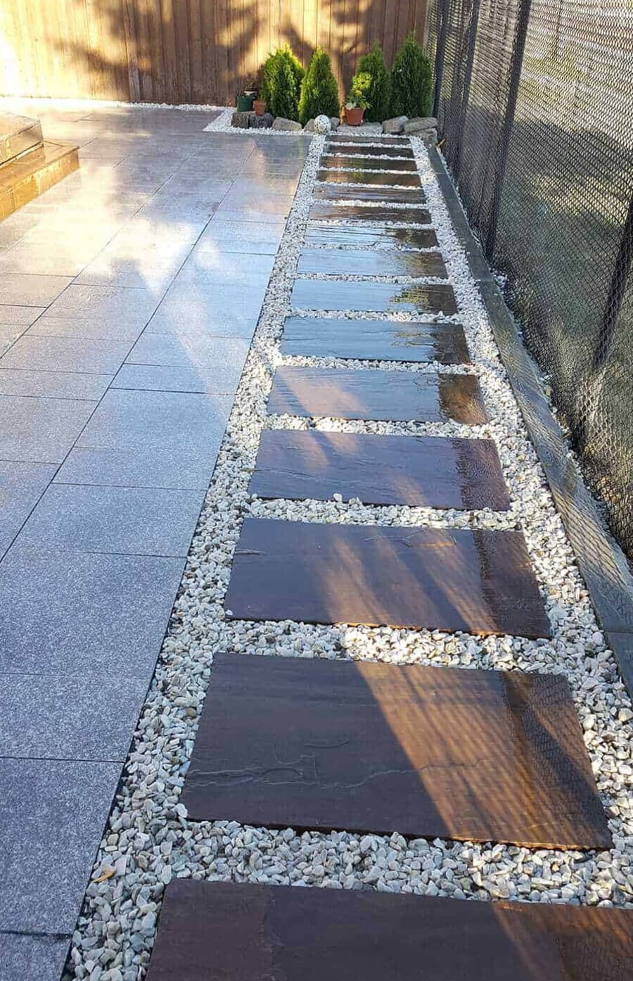 edge of a patio with decorative flagstones surrounded by small rock aggregate