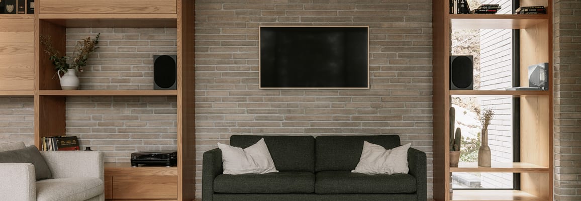 Interior wall with grey wall stone and wood shelving units.