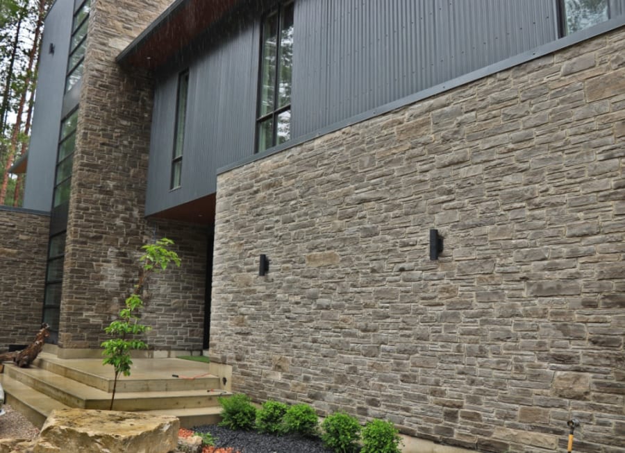 Multi-coloured grey and brown wall stone house.