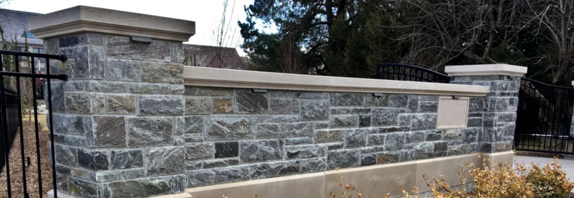 Grey wall stone fence for a gated house.