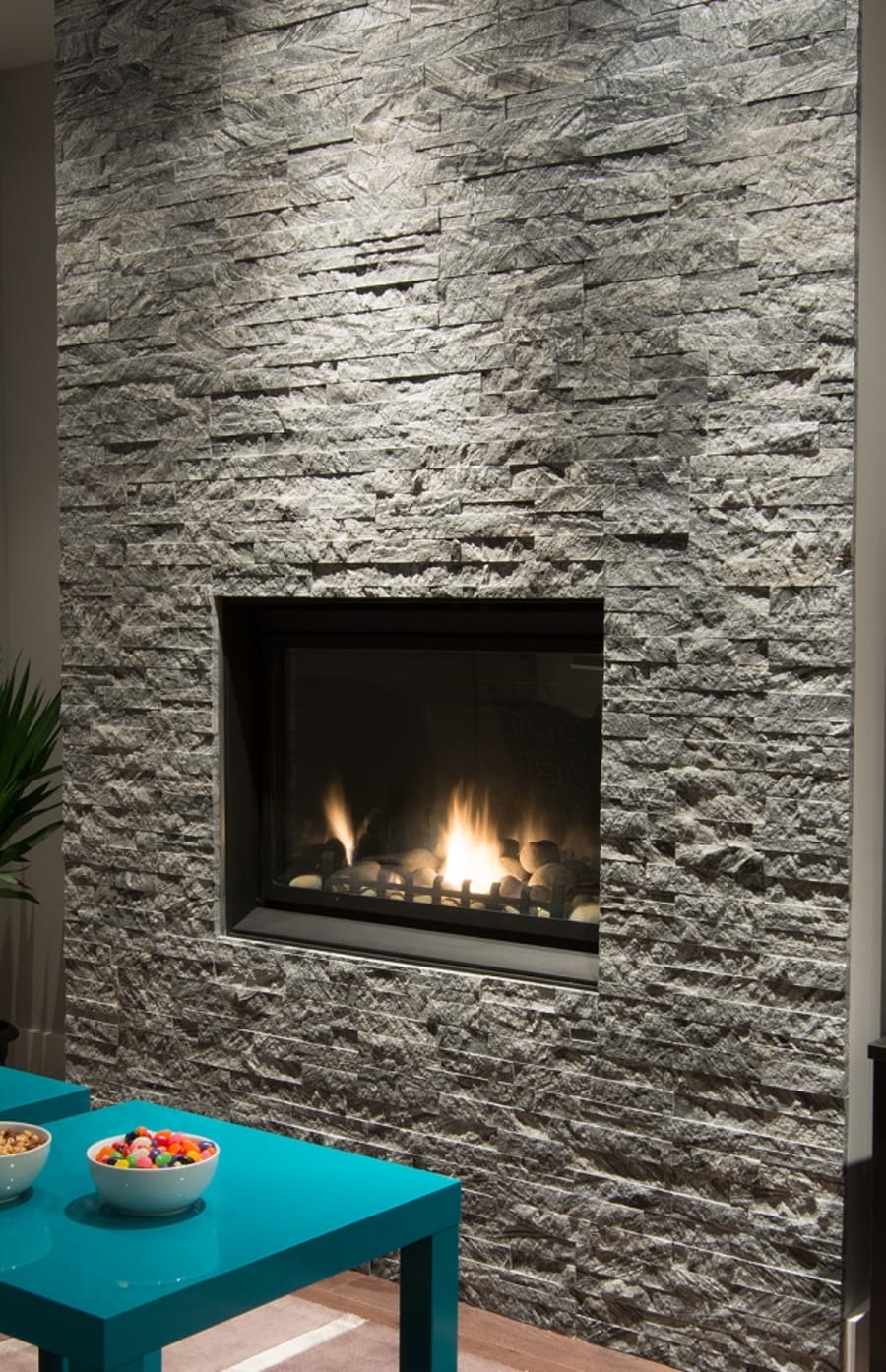 Grey modern fireplace with teal table filled with candy.