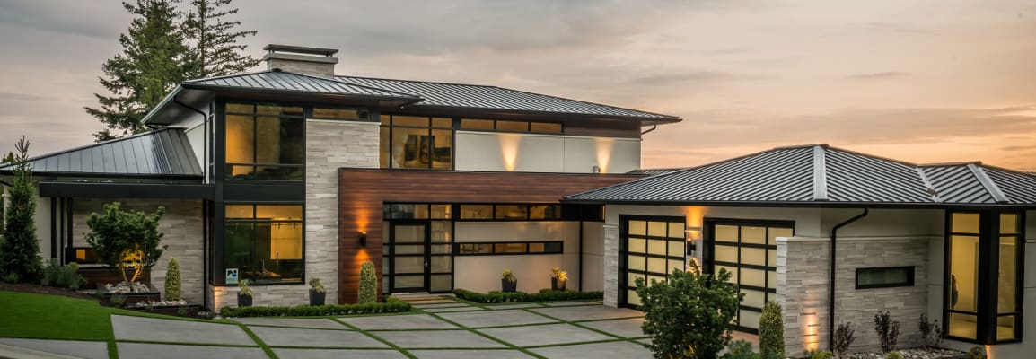 Modern house with light beige wall stone and a detached garage.