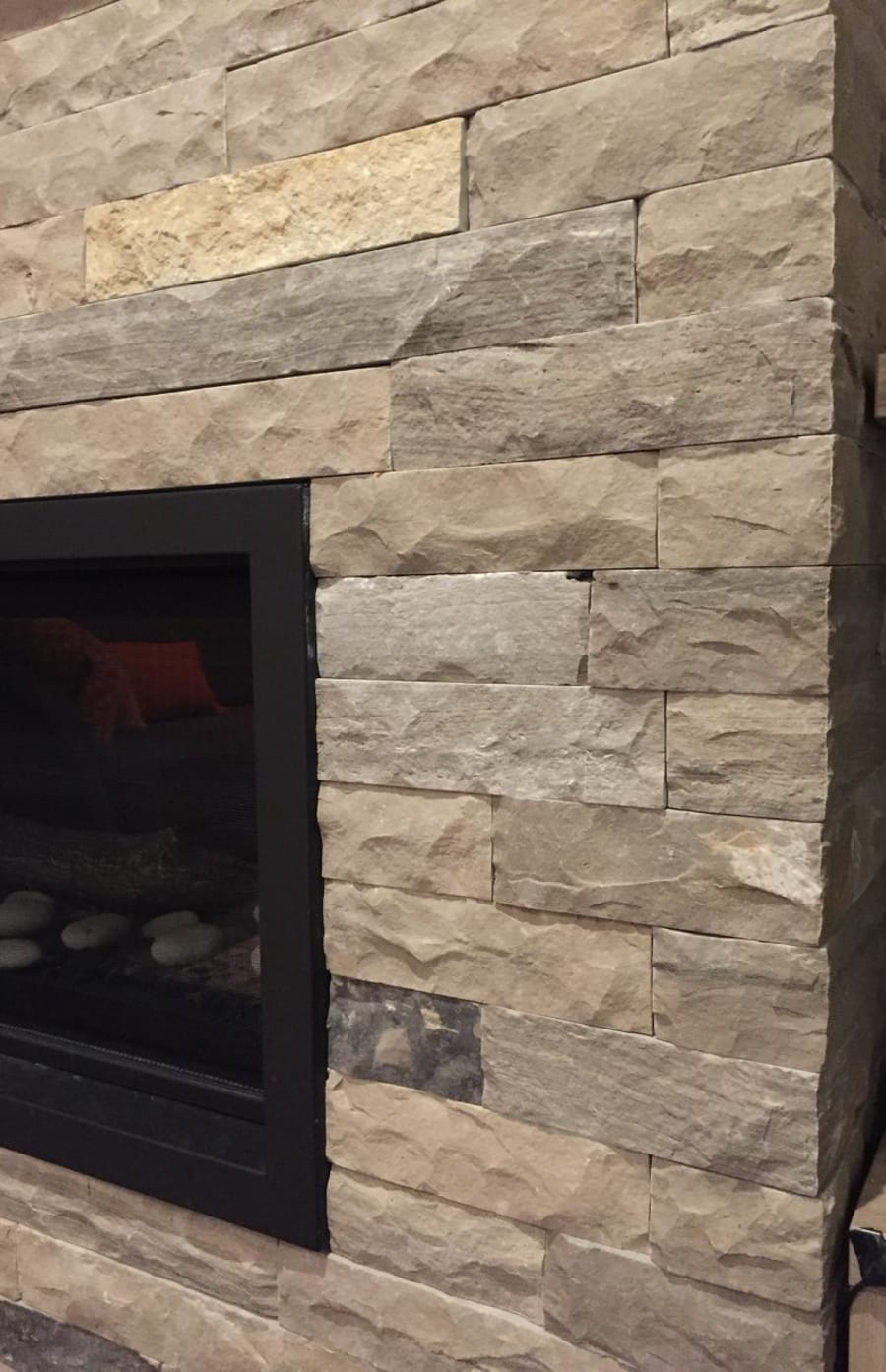 Interior fireplace with light beige wall stone.