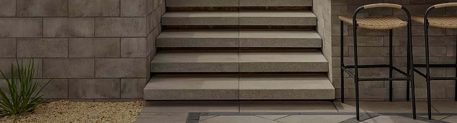 Exterior stairs and beige wall stone with bar stools.