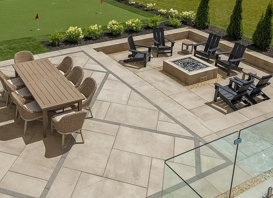 Large backyard patio with dining table and fire pit with chairs around it.