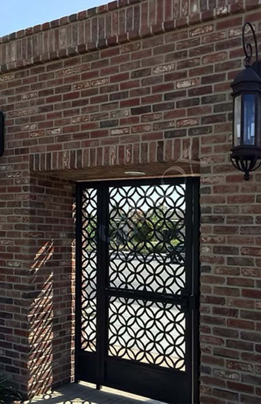 detailed wrought iron gate surrounded by red brick